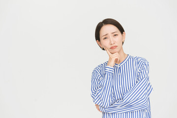 Fototapeta premium 健康的な日本人ミドル女性/スタジオ撮影白背景/困っている