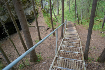Stainless steel ladder to the cave, Deer Ruchy Nature Park in the Sverdlovsk region, Karstovy Bridge rock.