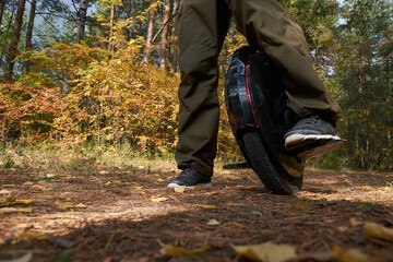 man rides down the trail on a monocycle. close up unicycle.