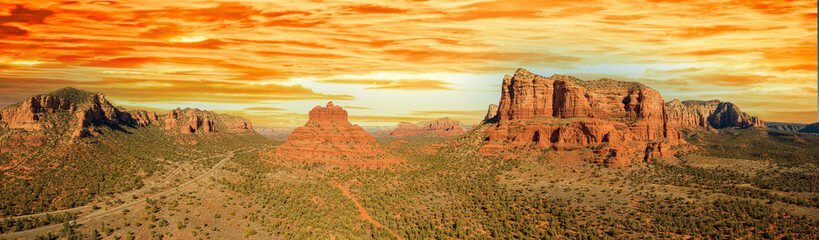 Aerial panorama of Bell Rock and Courthouse Butte in Sedona, Arizona with a bright blue clear sky.