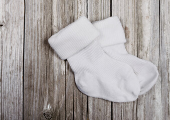 White baby socks on a wooden background