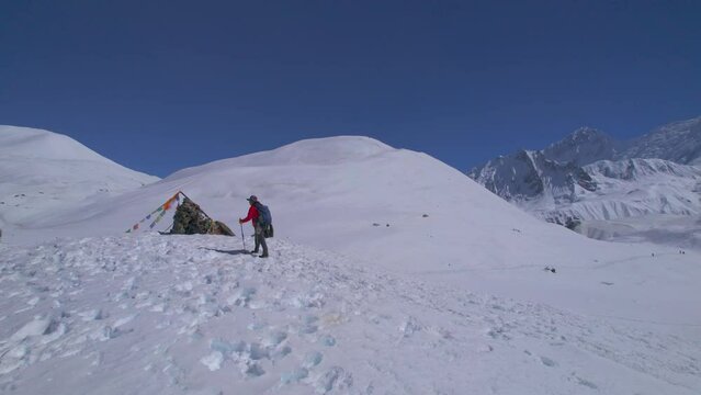 Aerial rising view caucasian male hiker on trekking trail go up with poles to Tilicho viewpoint in Himalayas.Annapurna circuit trek. Adventurer solo explore Himalaya mountains.