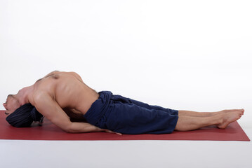 Man doing yoga in photo studio on isolated white background.