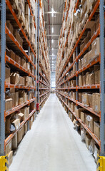 Hohes Industrie-Regal / Hochregal im Logistik-Center mit Schmalgang, Paletten, Pakete in großer Halle für Intralogistik