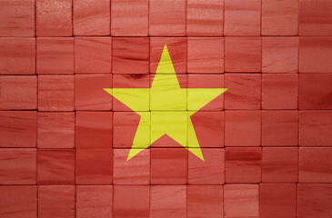 colorful painted big national flag of vietnam on a wooden cubes texture.