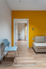 chair against the background of a doorway, a sofa and a yellow wall