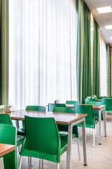 green dining chairs against the backdrop of green curtains in the dining room
