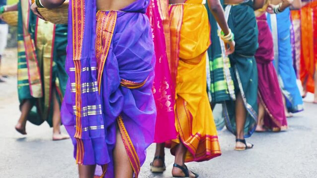 Indians dressed in colorful traditional attire are dancing at a festival