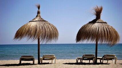 sunbeds on the beach under straw umbrellas