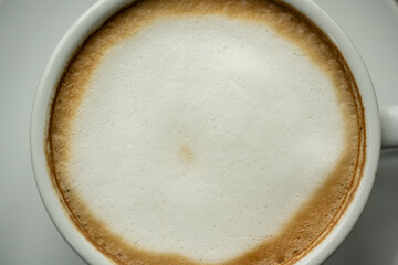 Top view white cup of hot coffee latte on wood background in restaurant.Top view with copyspace for...