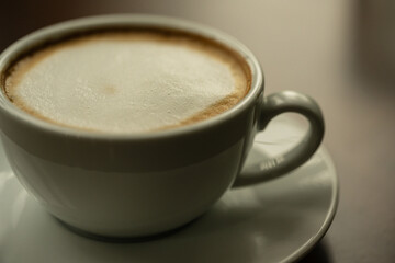Top view white cup of hot coffee latte on wood background in restaurant.Top view with copyspace for your text.