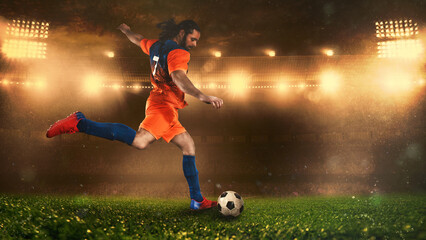 Fototapeta na wymiar Soccer scene at night match with player in a orange uniform kicking the ball with power