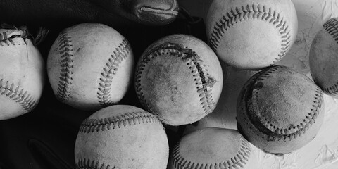 Group of old baseballs used in sports game, black and white background.