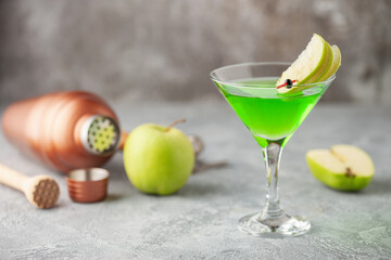 Alcoholic cocktail apple martini or green sour appletini in martini glass . Bar tools.
