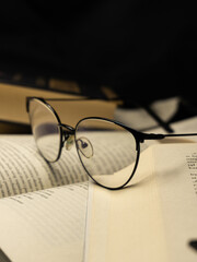 New paperback books, diary, fanned pages on wooden desk table and grunge background Daylight. Books stacking. Back to school. Copy Space. Education background, Reading background, glasses on book.