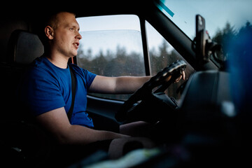 male trucker rides on a sunny day for a trip. Young van driver