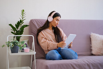 Asian woman watching movies, listening to music, video calling at home. High quality photo