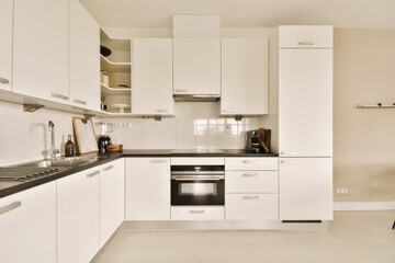 a kitchen with white cupboards and black counter tops on the counters in this is an example of modern design