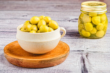 The bounty of nature: a wooden fountain and a glass jar overflowing with olives