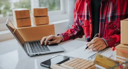 Close to entrepreneurs, small businesses, SMEs, freelance men working from home. Use a laptop for commercial auditing. online marketing Packaging Box SME Seller Concept Ecommerce Team online sales.