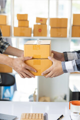Fototapeta na wymiar Two men's hands packing things for delivery SME business owner and start-up business