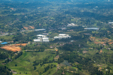 Fototapeta na wymiar Aerial View of Rionegro Mountains, Hills, Trees, Farms, Houses and Small Facilities in the Countryside near Medellin, Antioquia, Colombia
