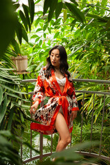 Woman resting in japanese garden. Wearing beach pareo