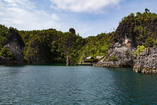 Huts and a pier in a bay of the national park of Raja Ampat, Indonesia