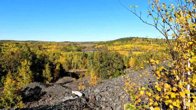 Panning view of autumn landscape and remains of Colonial Mine Site, as number 16 site in the Heritage Silver Trail in Cobalt Mining District National Historic Site, Ontario, Canada