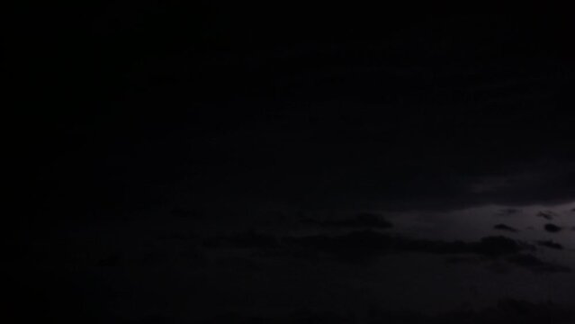 A strong thunderstorm with lightning in the clouds. Night sky during a summer storm. Natural disasters and climate change. Cyclic time lapse of lightning over city buildings during a severe storm.