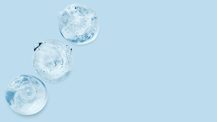 Drops and smears of a transparent gel or serum on a blue background. Banner with empty space for advertising.