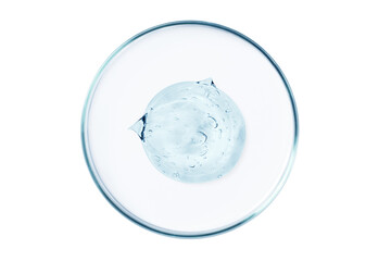 Petri dish with a drop and a smear of a transparent gel or serum on an empty background.