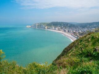 White cliffs of Etretat, Normandy, France,  with stunning view of the emerald sea ( the channel) and the blue sky in the background