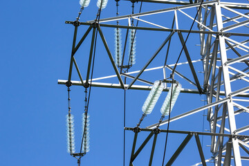 High voltage tower with electrical voltage wires isolates close-up against the background of...