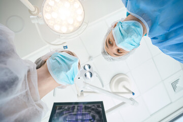 Surgeon dentist with an assistant are in the operating room