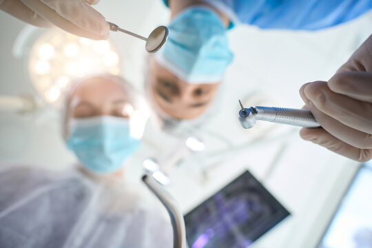 Surgeon dentist with dental mirror in his hands at workplace