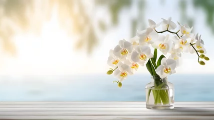 Foto auf Acrylglas white orchid flower decoration in a glass vase with sunlight on wooden table with copy space, floral spa background with spirit of purity © Prasanth