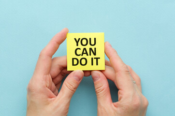 Woman hands holding white paper with text You can do it, Concept of motivation