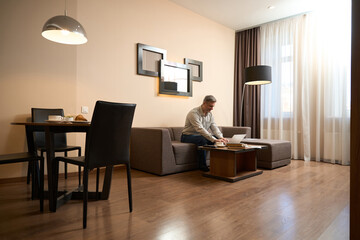 Adult happy man enjoying work on laptop