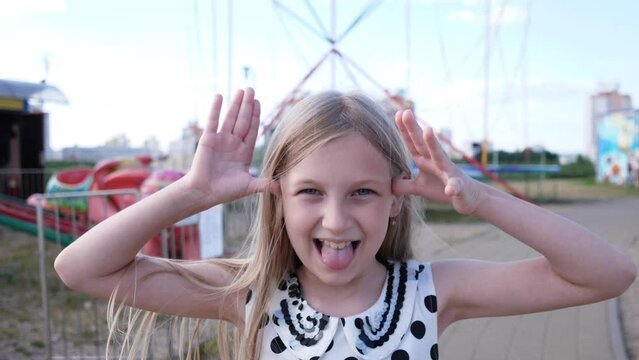 Little girl portrait grimaces in the park 4k