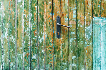 Rustic wooden door and handle with paint peeling off the surface as grunge background