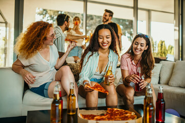 A group of friends gather for a group talk, eating pizza and having cocktails.