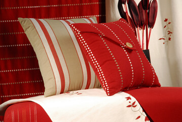 Red striped cushions with gift boxes, cloth and curtains and elegantly ornate red stool
