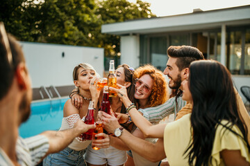 Poolside dancing, a group of friends groove to music near the pool, holding their cocktail bottles and dancing with infectious energy and joy.