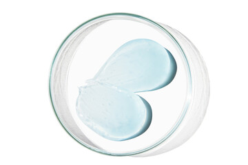 Petri dish with a drop and a smear of a transparent gel or serum on an empty background.