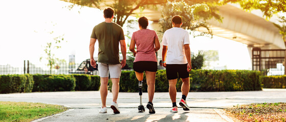 Friend support Friend with a prosthetic leg while exercising outdoor. People walking together on park outdoor. Exercise walking  woman with prosthetic leg and friend support together in  park outdoor