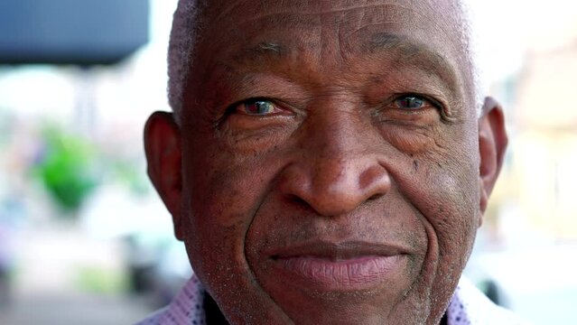 Close-up face of an African American elderly person looking at camera with neutral expression. A black senior Brazilian male person