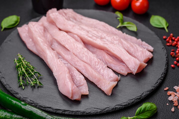 Raw chicken or turkey fillet cut into strips with spices and herbs