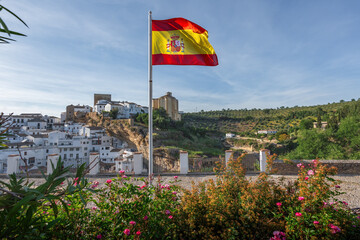 Flag of Spain and Setenil de las Bodegas Skyline - Setenil de las Bodegas, Andalusia, Spain - obrazy, fototapety, plakaty