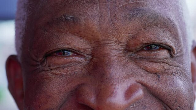 Macro close-up of a charismatic happy senior elderly person eyes staring at camera smiling with friendly emotion depicting wisdom and old age with wrinkles